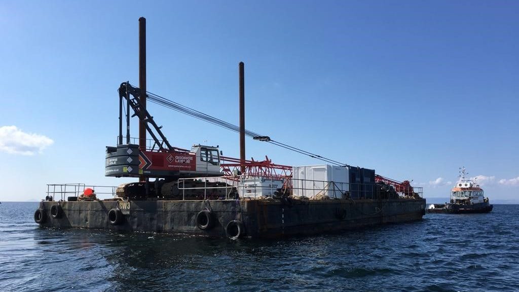 A George Leslie crane being towed on a barge in the ocean